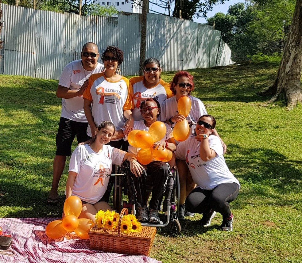 Moradora de Santos, a aposentada Emília Santos (ao centro) depende de uma cadeira de rodas para se locomover. — Foto: Arquivo Pessoal